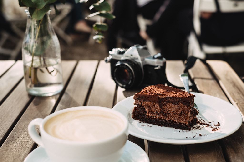 Taza de café con una porción de torta de chocolate