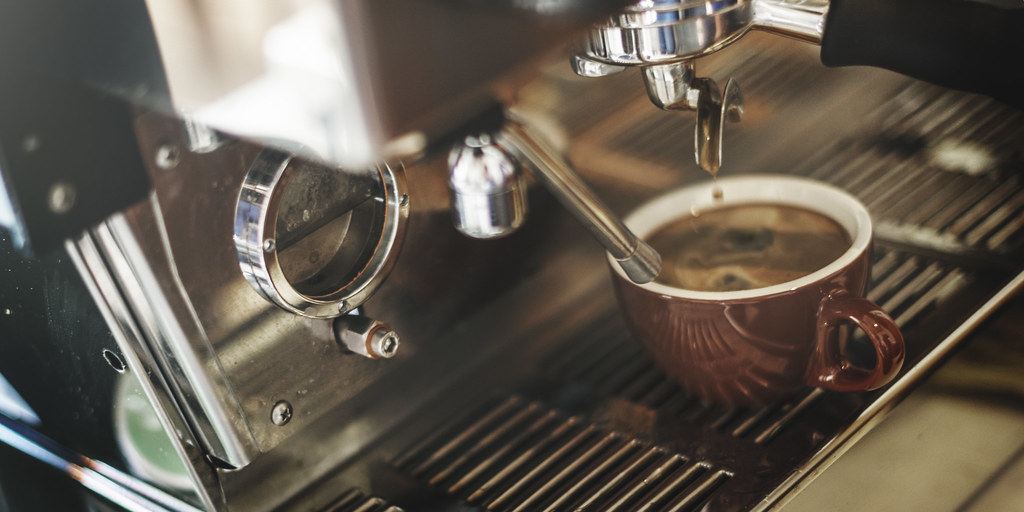 Espresso cayendo en una taza desde la máquina