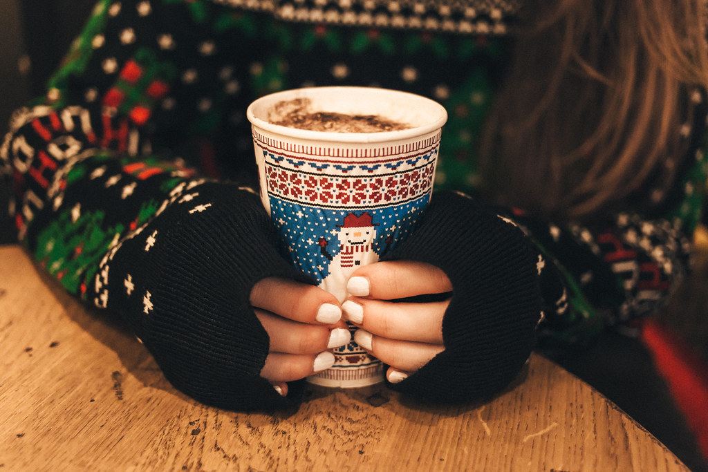 Manos sosteniendo una taza de café caliente